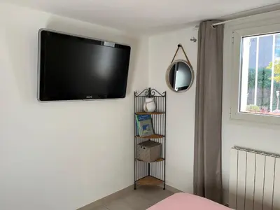 Télévision ou salle de divertissement dans l'établissement Appartement deux pièces donnant sur un jardin