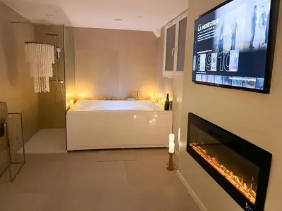 Télévision ou salle de divertissement dans l'établissement Romantique Room avec bain