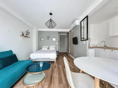 Un ou plusieurs lits dans un hébergement de l'établissement Studio proche gare, balcon