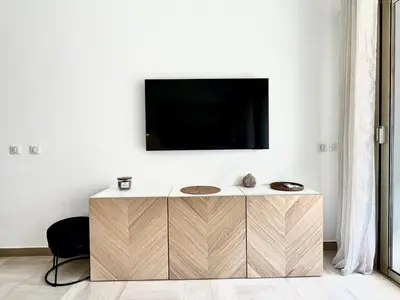 Télévision ou salle de divertissement dans l'établissement Marina Baie studio vue mer et jardin avec clim