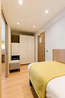 Un ou plusieurs lits dans un hébergement de l'établissement Hôtel Hélios