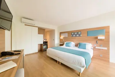 Un ou plusieurs lits dans un hébergement de l'établissement Hôtel Hélios
