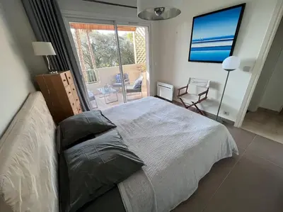 Un ou plusieurs lits dans un hébergement de l'établissement Appartement climatisé avec terrasse, vue jardin et piscine